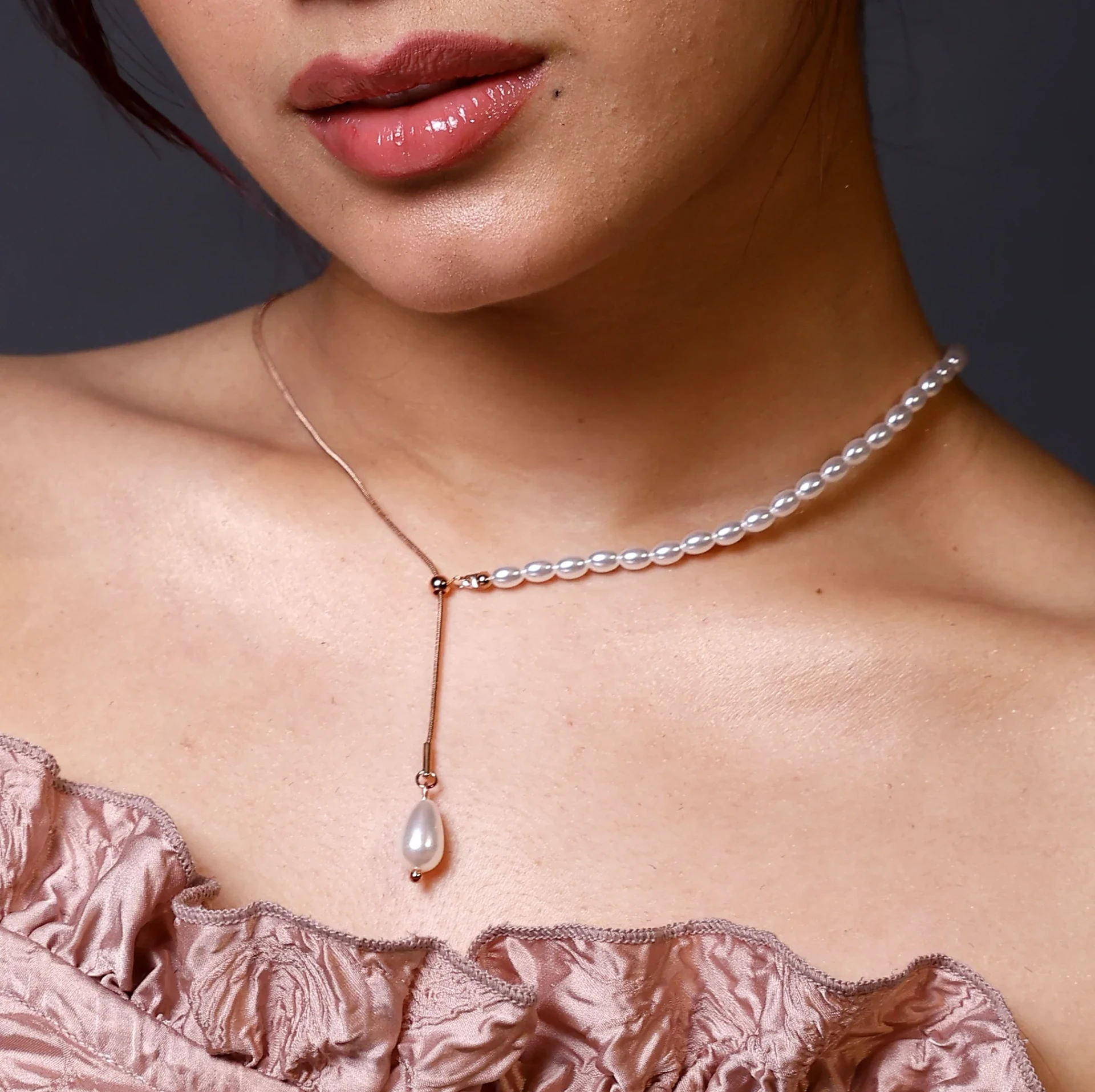 Close-up of the pearl tassel slider necklace with lustrous pearls and gold slider chain